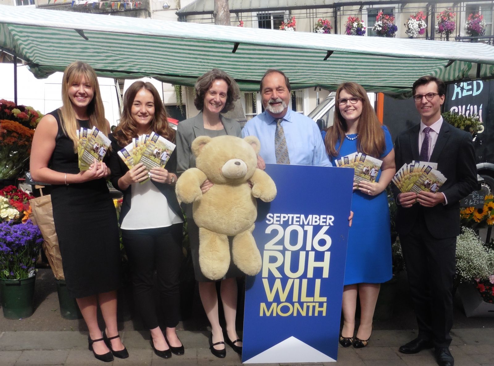 Group of people including Leanna Knight, James Hollis and jane HJealey of FDC Law holding teddy bear and leaflets